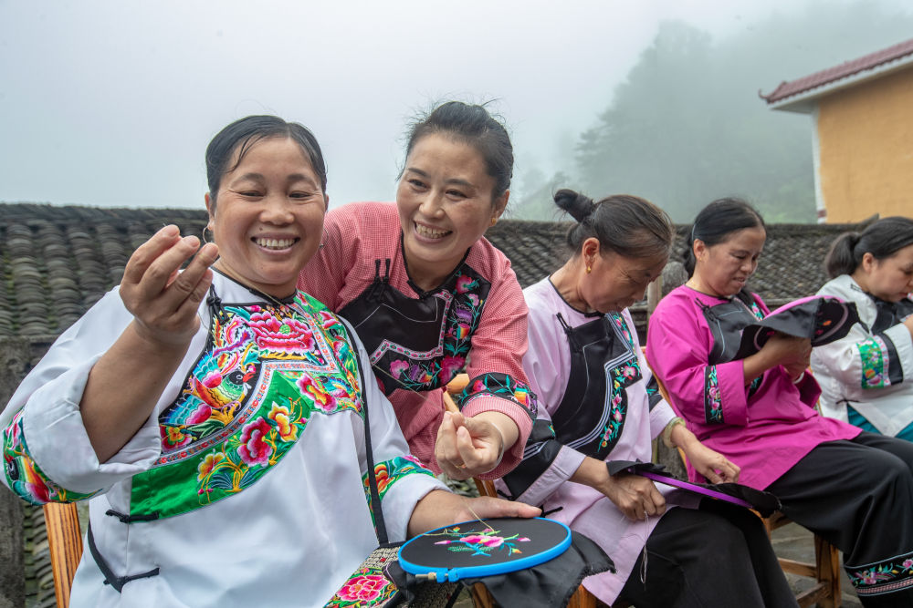 在湖南省湘西土家族苗族自治州花垣县十八洞村，村民在讨论苗绣制作（2020年7月16日摄）。
